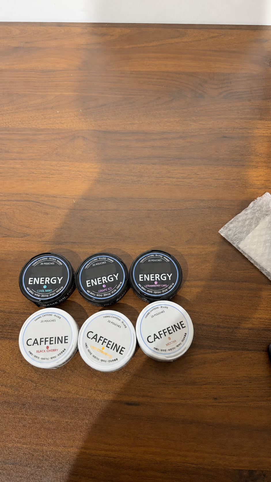 An anonymized grouped display of caffeine and energy pouch cans for a Korea-directed order.